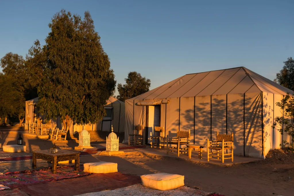 Merzouga Desert Tour – Camel Trek, Desert Camp & Sahara Sunrise traditional Berber desert camp at golden hour Merzouga Morocco